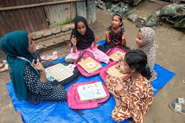 One Carries a Broom, the Other a Schoolbag